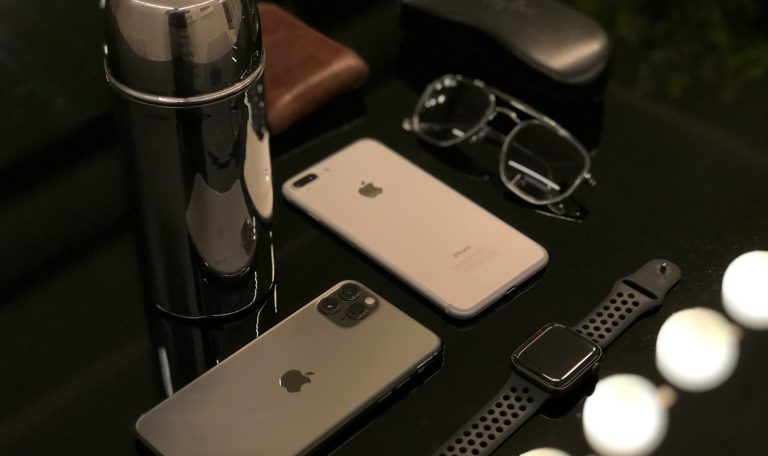 silver iphone 6 beside silver macbook and black framed eyeglasses